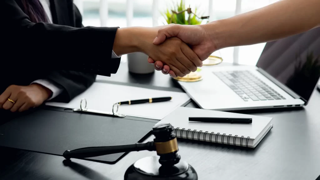 Omaha truck accident lawyer shaking hands with a client over an office table in Nebraska.